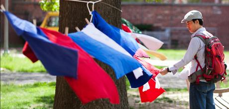 A Student examines flags on the University Yard