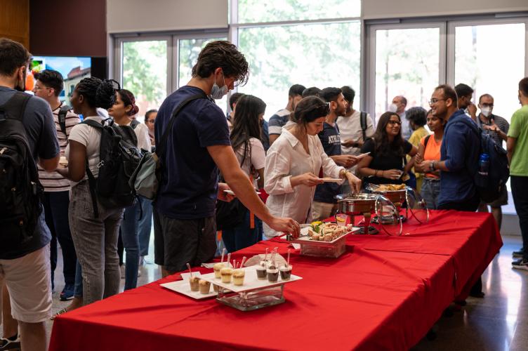 A table of appetizers with students standing around