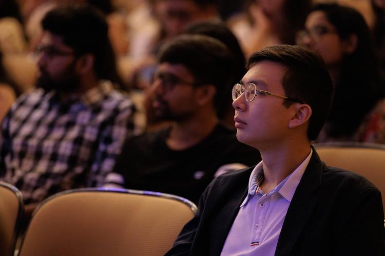 A student sitting in a theatre watching a presentation