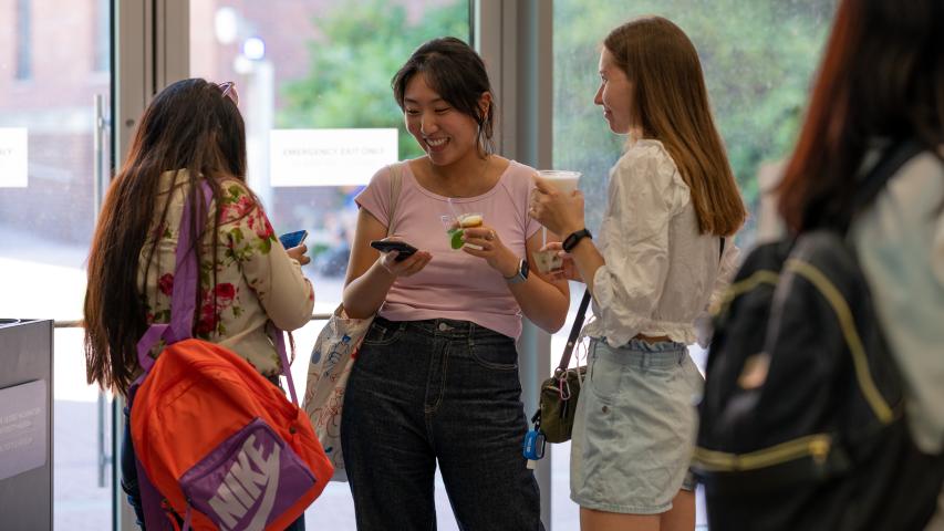 Students holding drinks and smiling